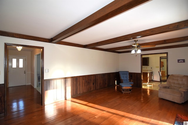 living room with beamed ceiling, wood-type flooring, and ceiling fan