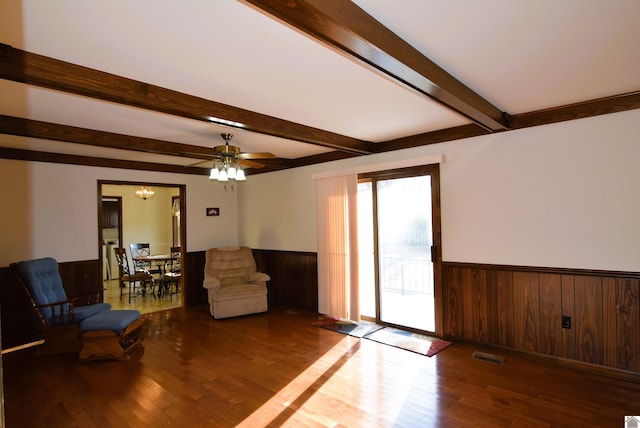 living room with hardwood / wood-style floors, ceiling fan, and wooden walls