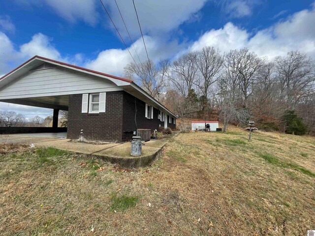 3480 Radio Rd, Almo, KY 42020 - view of side of home with a carport, central AC unit, and a lawn