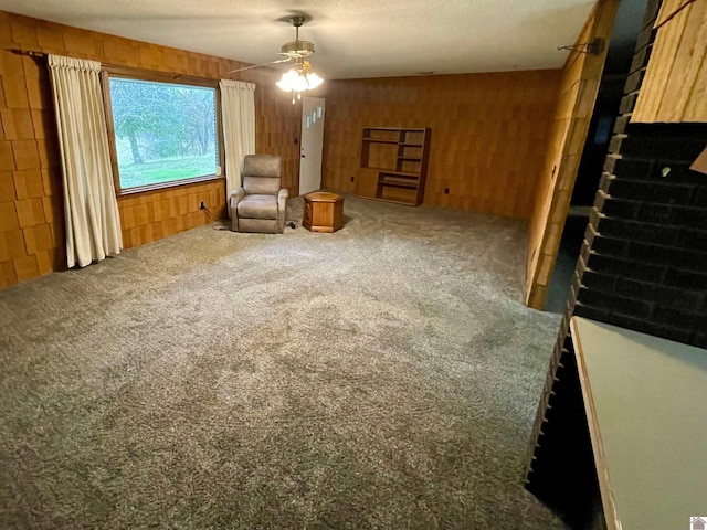 3480 Radio Rd, Almo, KY 42020 - living area with carpet flooring, a textured ceiling, ceiling fan, and wooden walls