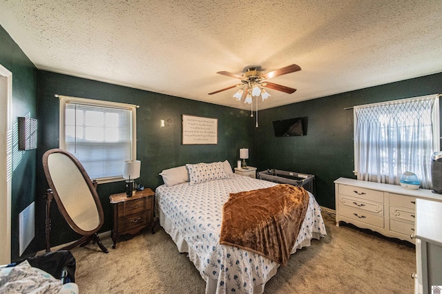 bedroom featuring ceiling fan, light carpet, and a textured ceiling