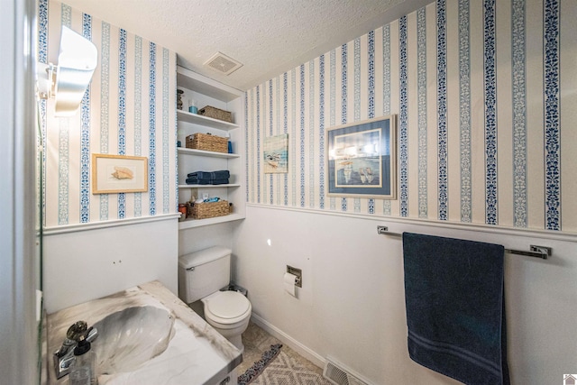 bathroom featuring sink, toilet, and a textured ceiling