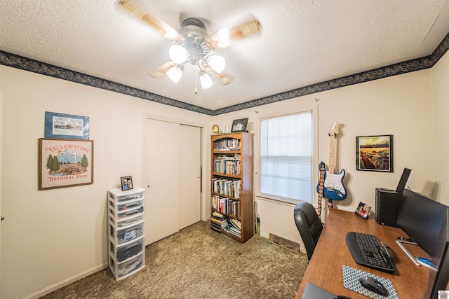 home office featuring ceiling fan, carpet floors, and a textured ceiling