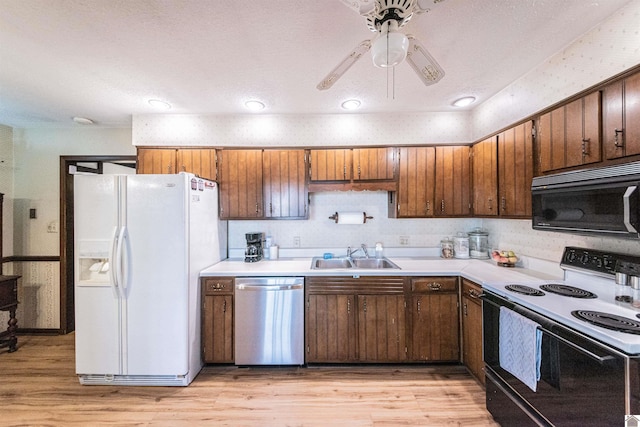 kitchen with ceiling fan, white appliances, sink, and light hardwood / wood-style flooring