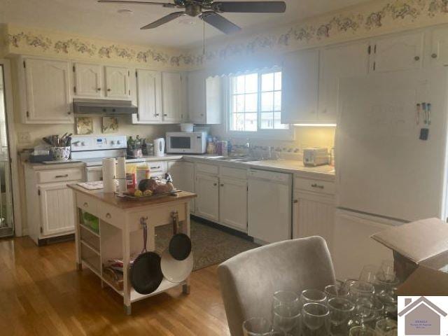 kitchen featuring sink, ceiling fan, hardwood / wood-style flooring, white appliances, and white cabinets