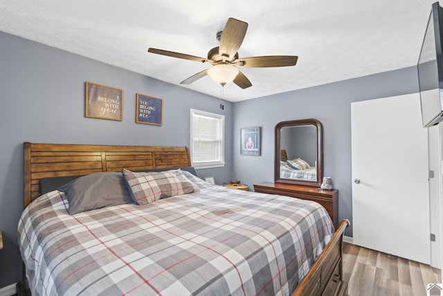 bedroom featuring a textured ceiling, light hardwood / wood-style floors, and ceiling fan