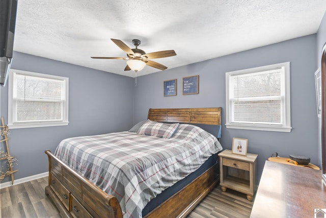 bedroom featuring ceiling fan, dark hardwood / wood-style flooring, and a textured ceiling