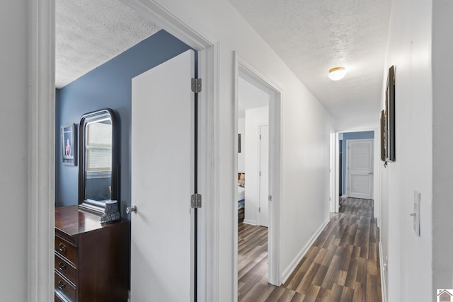 hallway featuring a textured ceiling and dark hardwood / wood-style floors