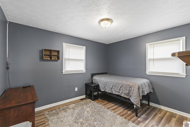 bedroom with hardwood / wood-style flooring and a textured ceiling