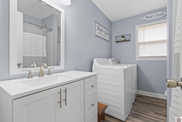 bathroom featuring washer and clothes dryer, hardwood / wood-style floors, and vanity