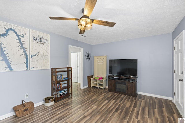 living room with a textured ceiling, dark hardwood / wood-style floors, and ceiling fan