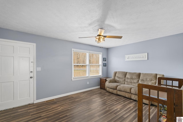 living room featuring a textured ceiling, ceiling fan, and dark hardwood / wood-style floors