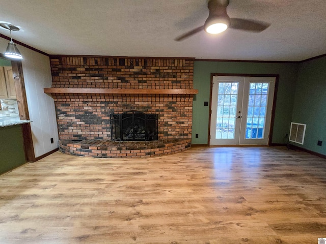 unfurnished living room featuring a textured ceiling, visible vents, ornamental molding, ceiling fan, and wood finished floors
