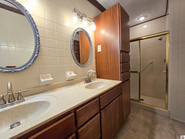 bathroom featuring tile patterned floors, a sink, tile walls, and a textured ceiling