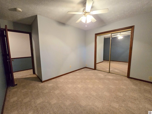 unfurnished bedroom with carpet floors, baseboards, a closet, and a textured ceiling