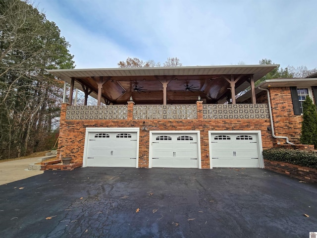 garage featuring aphalt driveway and a ceiling fan