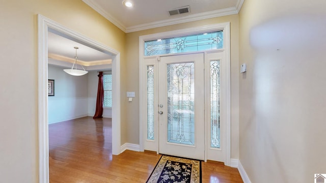 foyer entrance with crown molding and light hardwood / wood-style floors