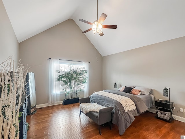 bedroom with ceiling fan, hardwood / wood-style floors, and high vaulted ceiling