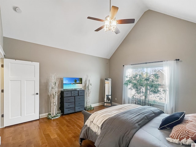 bedroom featuring hardwood / wood-style floors, high vaulted ceiling, and ceiling fan