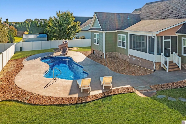 view of swimming pool featuring a sunroom, a patio area, and a lawn