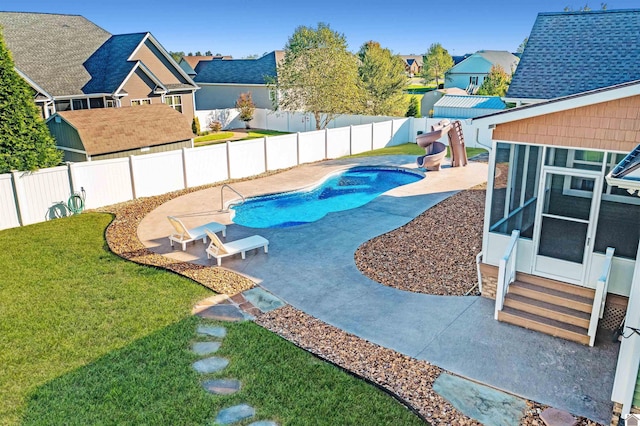 view of pool featuring a sunroom, a yard, and a patio