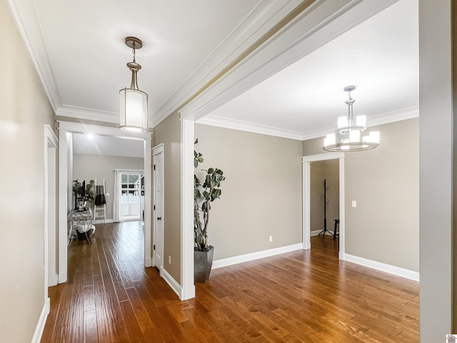 hallway with crown molding, hardwood / wood-style floors, and a notable chandelier