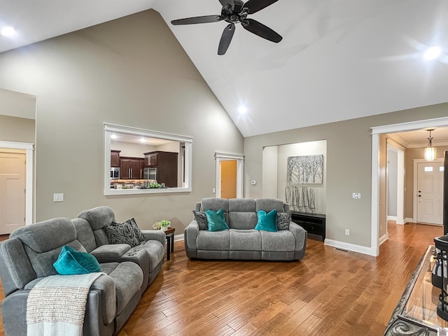 living room featuring hardwood / wood-style floors, ceiling fan, crown molding, and high vaulted ceiling