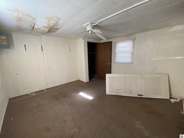 basement featuring ceiling fan and radiator heating unit