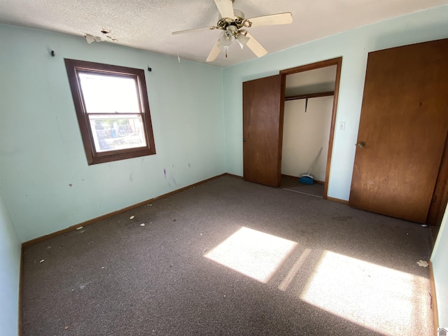 unfurnished bedroom featuring carpet flooring, ceiling fan, and a textured ceiling