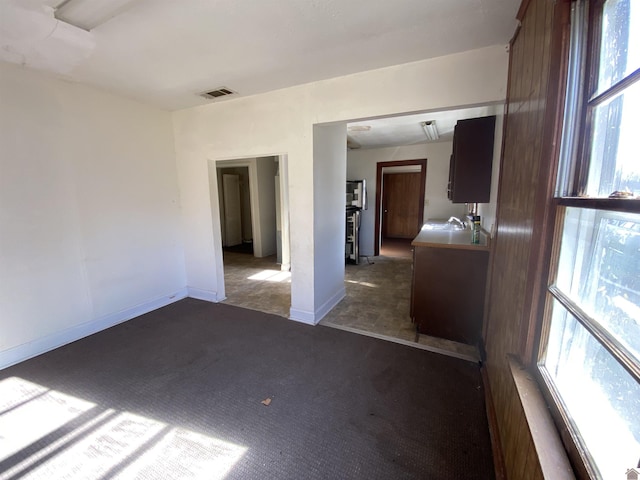 empty room with dark colored carpet and sink