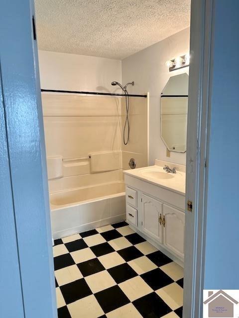 bathroom with vanity, a textured ceiling, and shower / bathtub combination