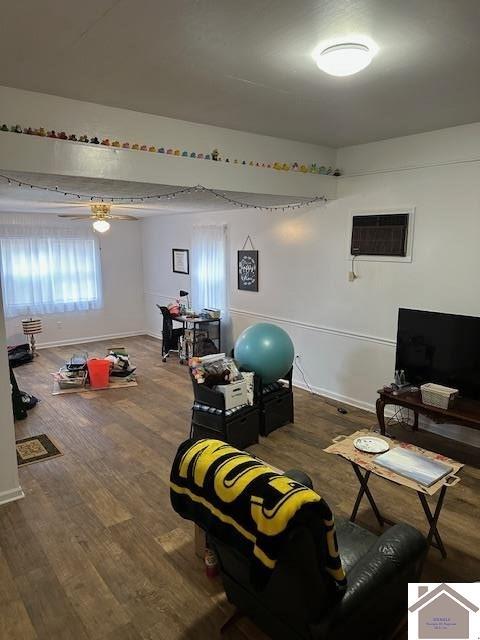 exercise room with dark hardwood / wood-style floors, ceiling fan, and a wall mounted AC