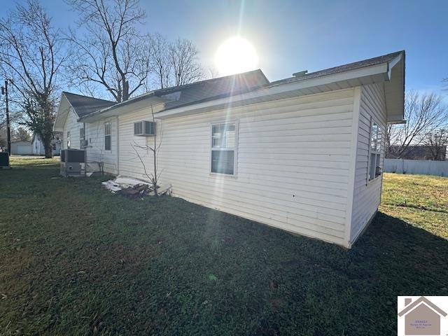 view of property exterior with a yard and central AC unit