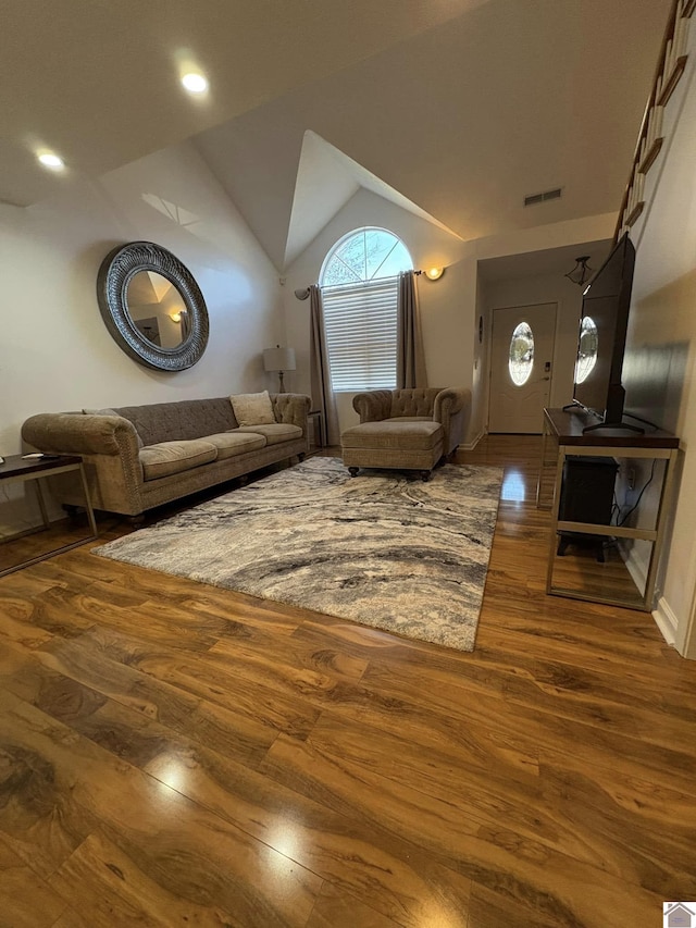 unfurnished living room featuring hardwood / wood-style flooring and vaulted ceiling