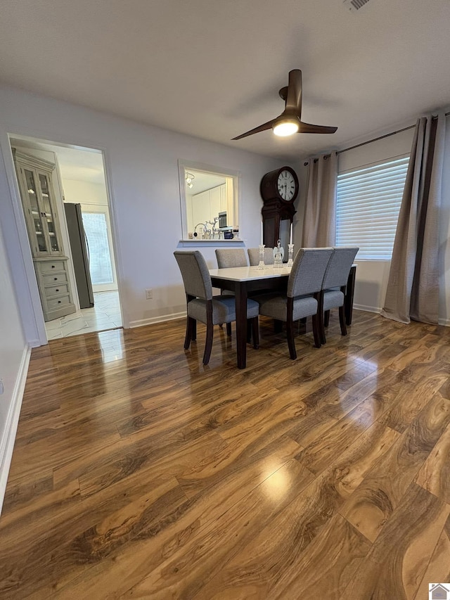 dining area with ceiling fan and wood-type flooring