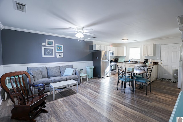 living room featuring dark hardwood / wood-style flooring, ceiling fan, crown molding, and sink