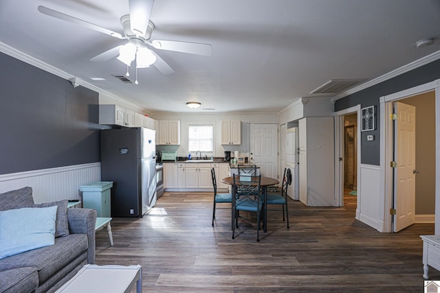 dining room with sink, dark hardwood / wood-style floors, ceiling fan, ornamental molding, and washer / dryer