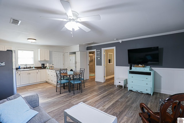 living room with ceiling fan, hardwood / wood-style floors, ornamental molding, and sink