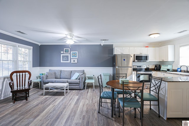 interior space with hardwood / wood-style floors, ceiling fan, and ornamental molding