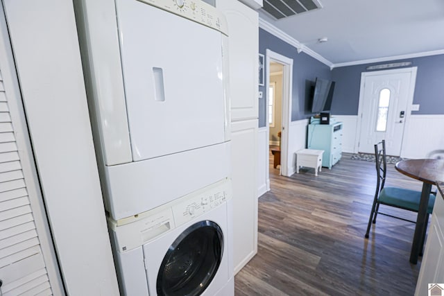 washroom with dark hardwood / wood-style flooring, stacked washing maching and dryer, and ornamental molding