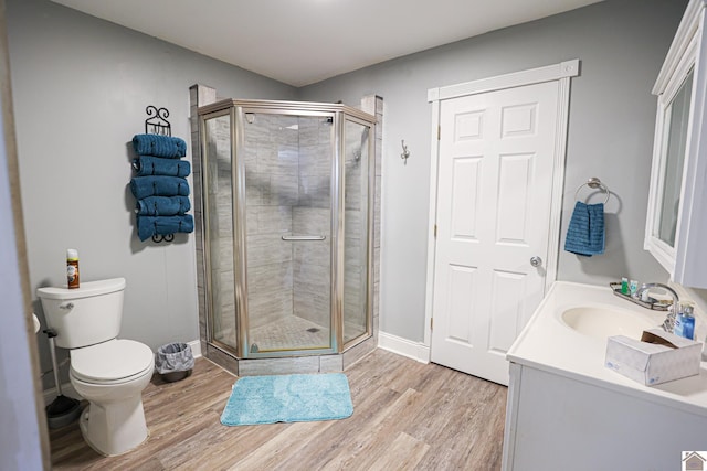 bathroom with vanity, wood-type flooring, an enclosed shower, and toilet