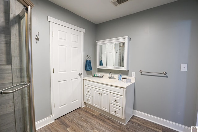 bathroom featuring vanity, a shower with shower door, and hardwood / wood-style flooring