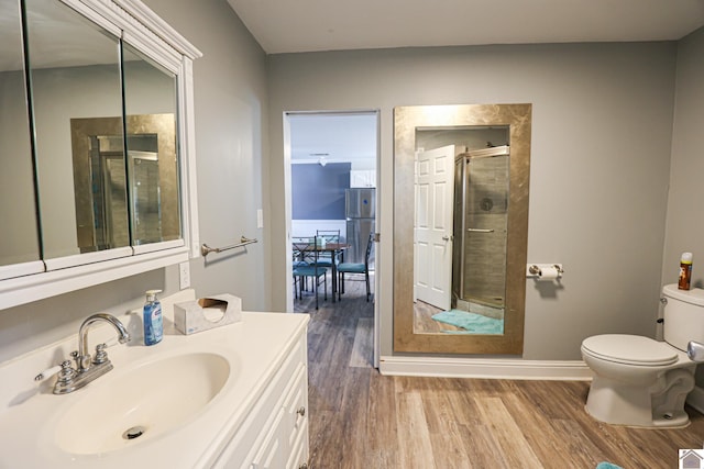 bathroom featuring hardwood / wood-style floors, vanity, an enclosed shower, and toilet