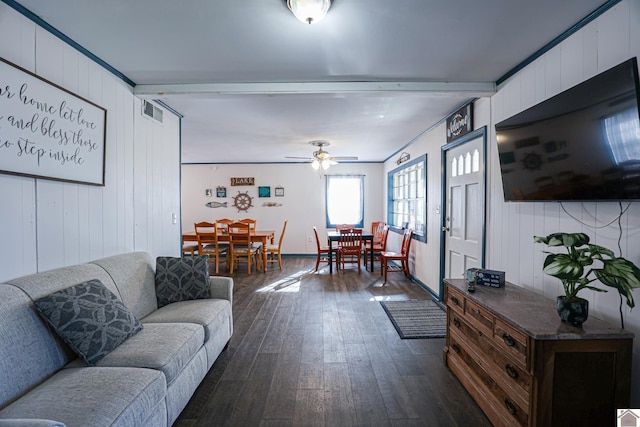 living room with wood walls, ceiling fan, ornamental molding, beamed ceiling, and dark hardwood / wood-style flooring