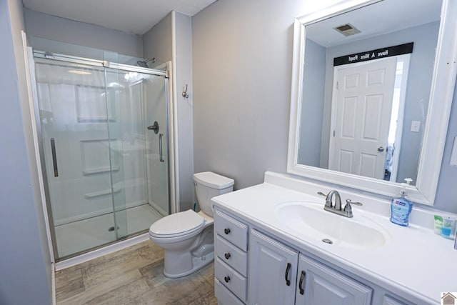 bathroom featuring vanity, hardwood / wood-style flooring, toilet, and an enclosed shower