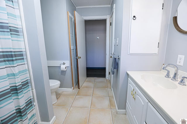 bathroom with toilet, vanity, and tile patterned floors