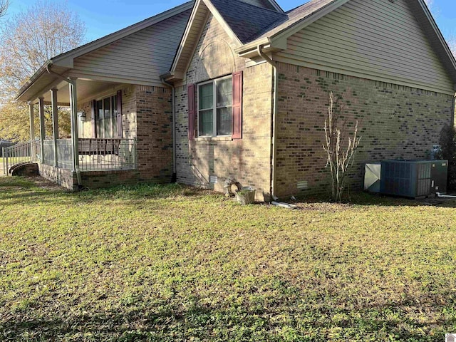 view of side of home with a lawn and cooling unit