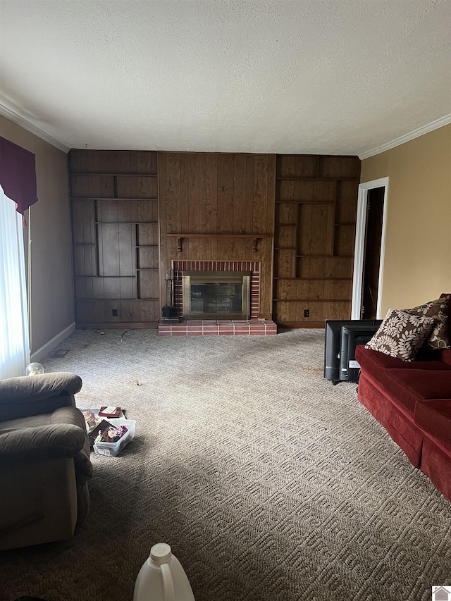 carpeted living room with a textured ceiling, wood walls, crown molding, and a fireplace