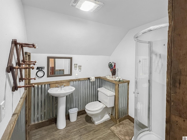 bathroom featuring lofted ceiling, a shower with door, sink, hardwood / wood-style flooring, and toilet