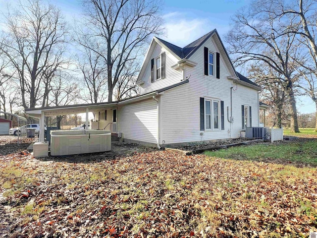 rear view of house featuring a hot tub